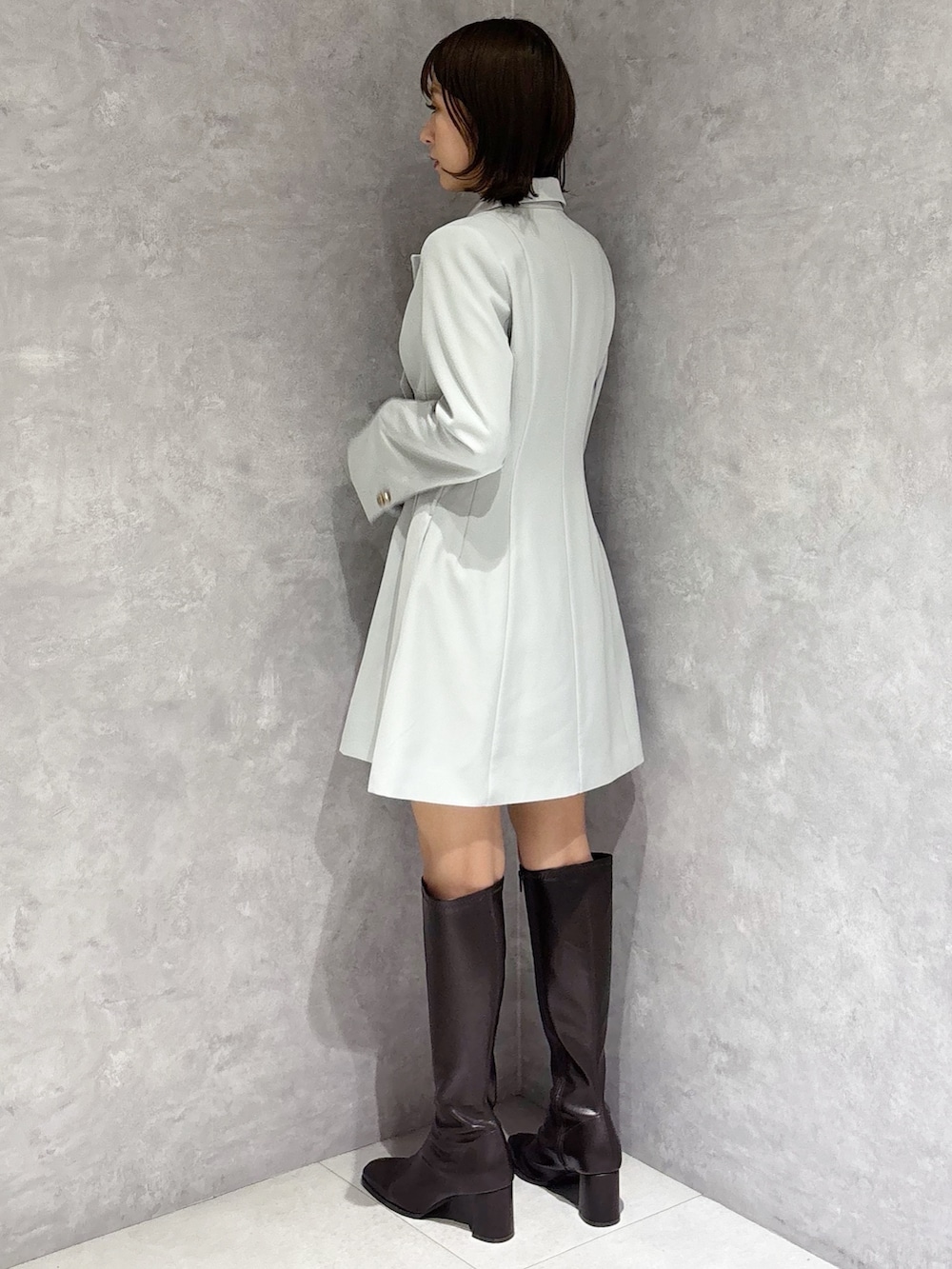 グリーン系のワンピース、ブラウン系のブーツを着用したレディースの冬コーディネートの2枚目の写真