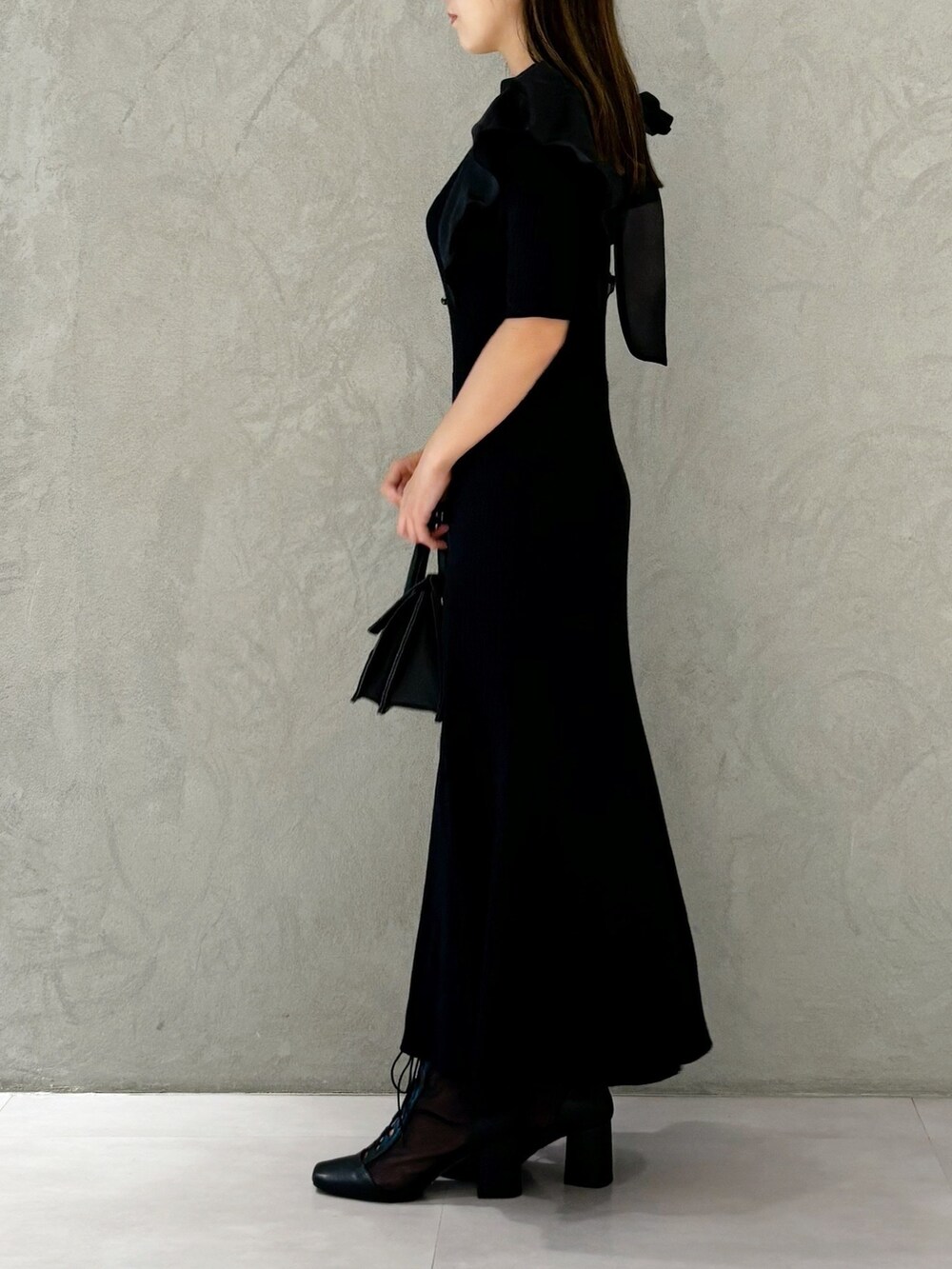 ブラック系のワンピース、ブラック系のショルダーバッグ、ブラック系のブーツを着用したレディースの夏コーディネートの5枚目の写真