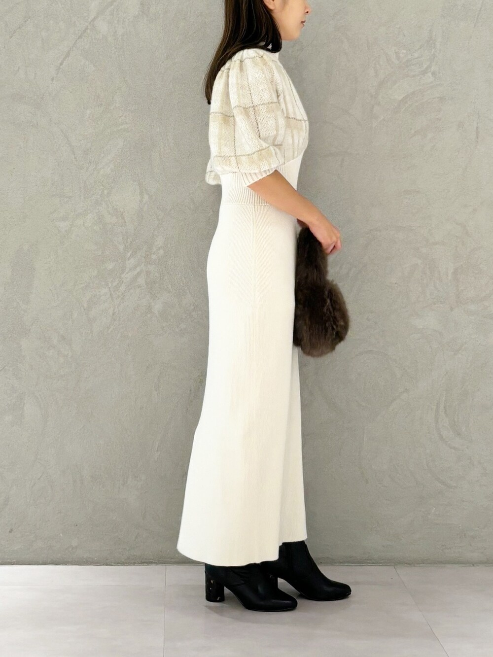 ホワイト系のワンピース、ブラック系のブーツ、ブラウン系のハンドバッグを着用したレディースの秋コーディネートの3枚目の写真