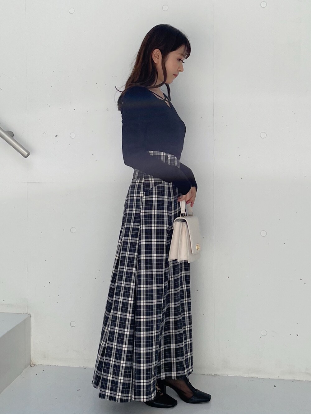 ブラック系のスカート、ブラック系のブーツ、ブラック系のニット/セーターを着用したレディースの秋コーディネートの3枚目の写真