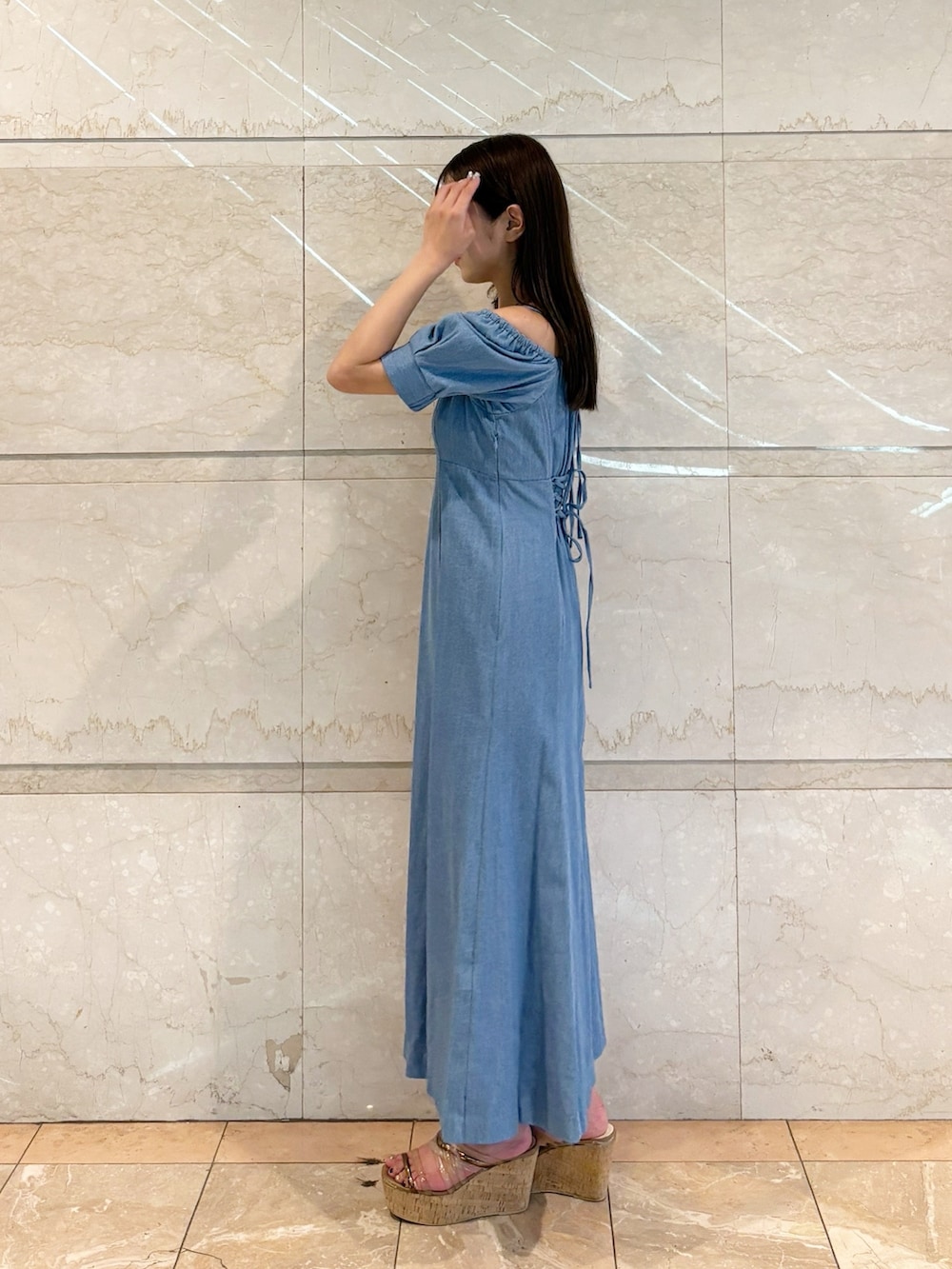 ブルー系のワンピース、ブラウン系のサンダルを着用したレディースの春コーディネートの2枚目の写真