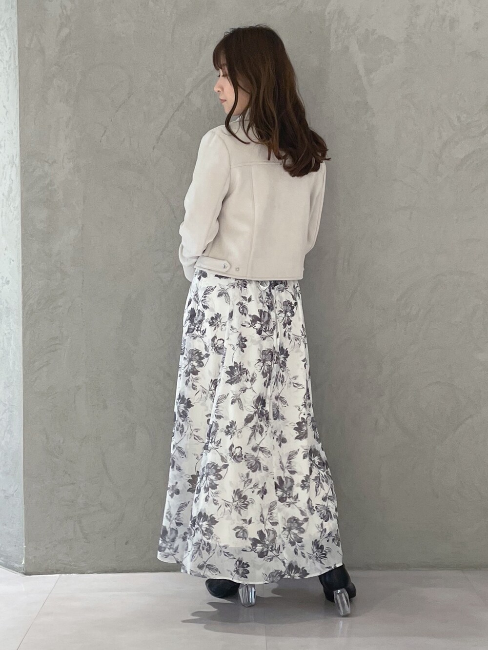 ホワイト系のワンピース、ピンク系のライダースジャケットを着用したレディースの冬コーディネートの3枚目の写真