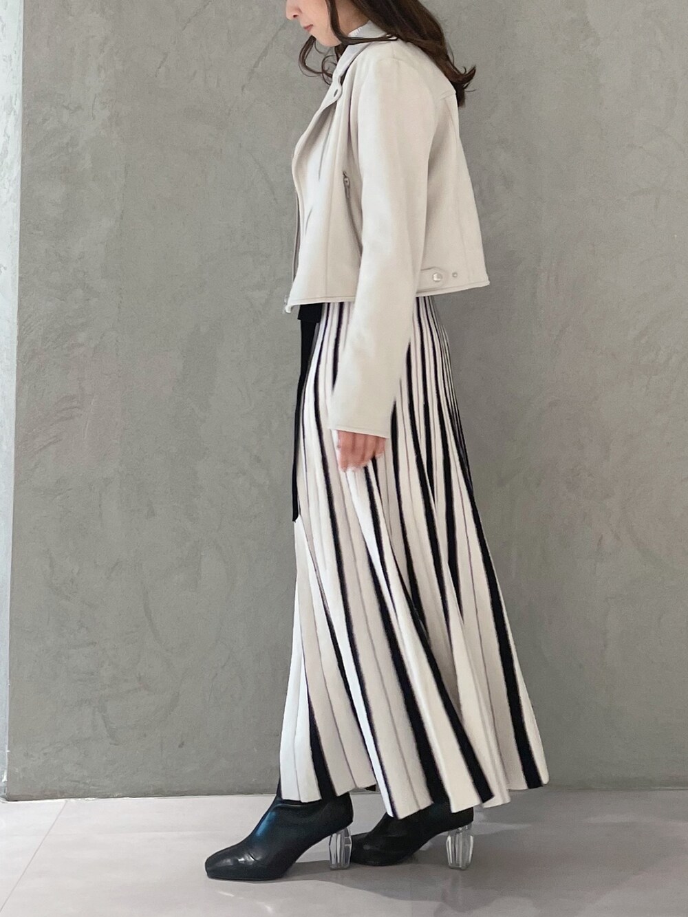 ホワイト系のワンピース、ピンク系のライダースジャケット、ホワイト系のハンドバッグを着用したレディースの春コーディネートの5枚目の写真