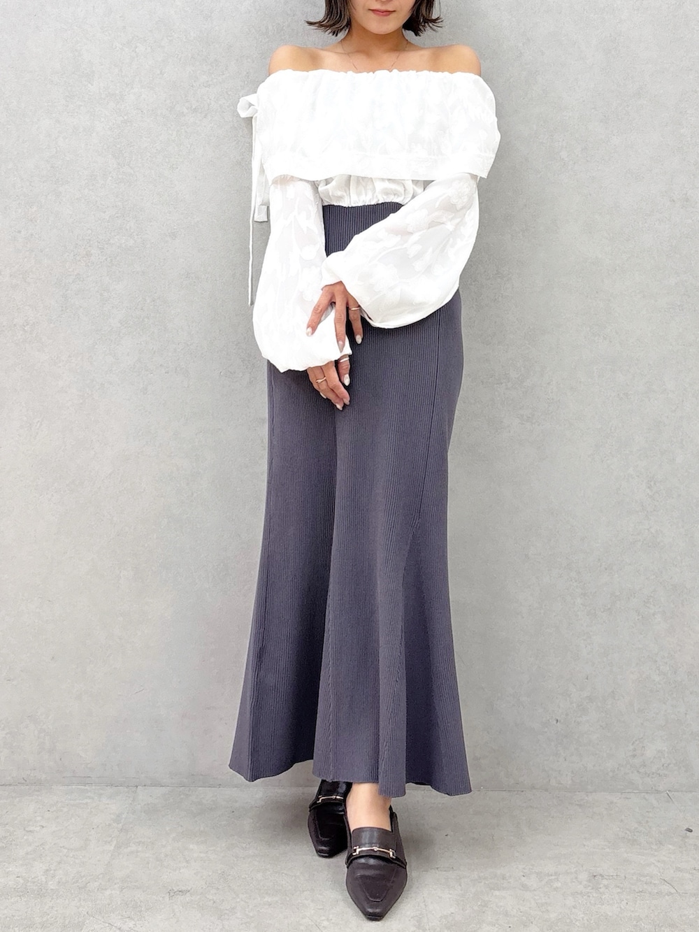 ブラウン系のパンプス、グレー系のワンピースを着用したレディースの冬コーディネートの8枚目の写真