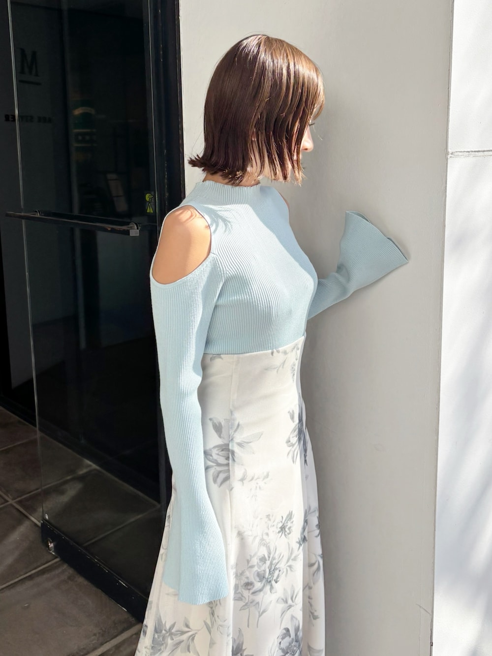 ホワイト系のスカート、グリーン系のニット/セーター、ホワイト系のパンプスを着用したレディースの春コーディネートの4枚目の写真