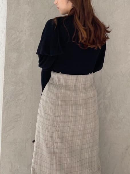 ブラウン系のハンドバッグ、グレー系のスカート、ブラック系のニット/セーターを着用したレディースの秋コーディネートの6枚目の写真