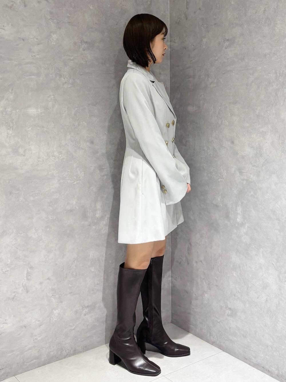 グリーン系のワンピース、ブラウン系のブーツを着用したレディースの冬コーディネートの3枚目の写真