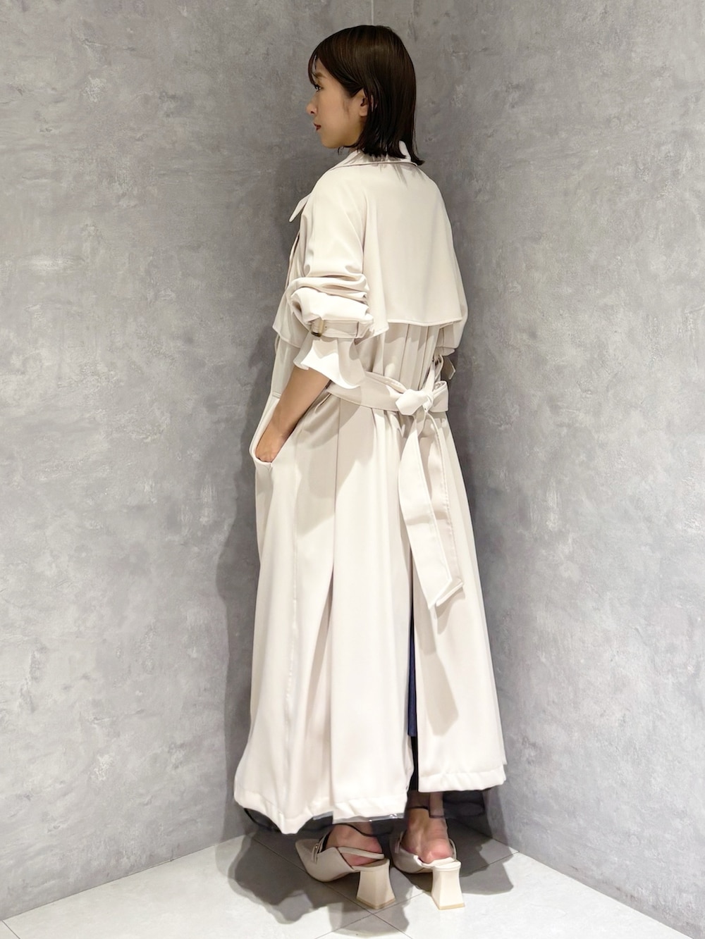 ブルー系のスカート、ホワイト系のニット/セーター、ホワイト系のパンプスを着用したレディースの春コーディネートの3枚目の写真