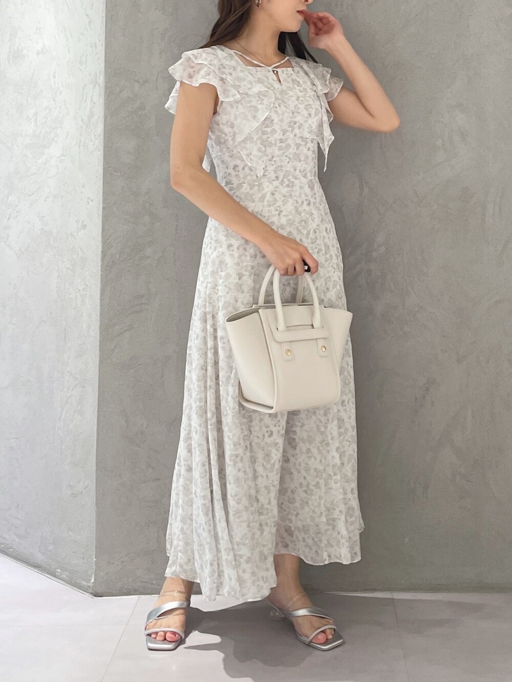 ホワイト系のワンピース、シルバー系のサンダル、ホワイト系のトートバッグを着用したレディースの夏コーディネートの2枚目の写真