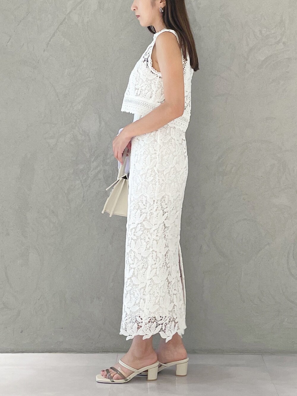 ベージュ系のショルダーバッグ、ホワイト系のサンダル、パープル系のカーディガン/ボレロを着用したレディースの夏コーディネートの5枚目の写真