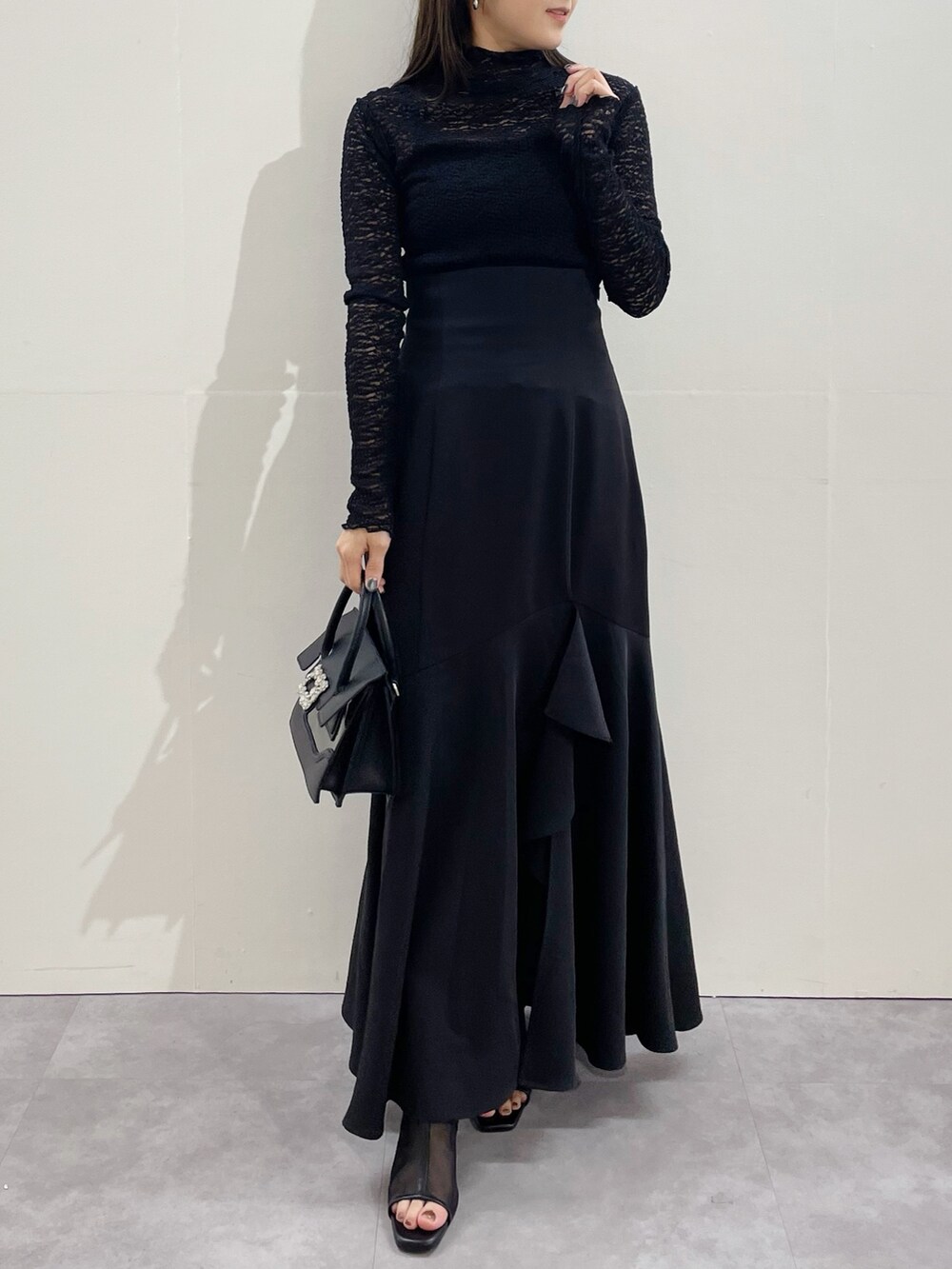 ブラック系のスカート、ブラック系のブーツ、ブラック系のTシャツ/カットソーを着用したレディースの冬コーディネートの7枚目の写真