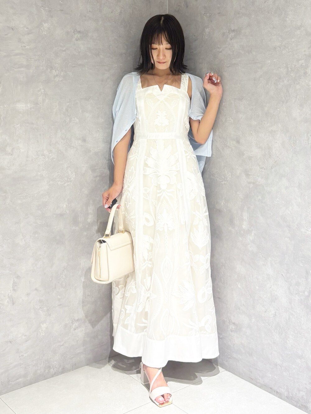 ホワイト系のワンピース、ホワイト系のサンダル、ホワイト系のハンドバッグを着用したレディースの夏コーディネートの6枚目の写真