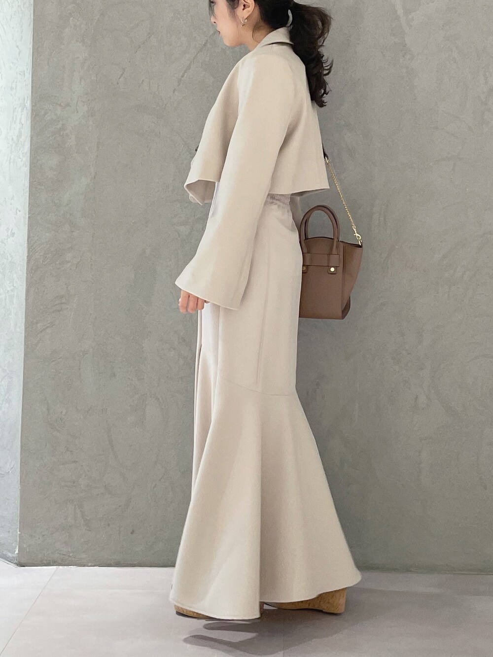 ブラック系のサンダル、ベージュ系のスカート、イエロー系のニット/セーターを着用したレディースの春コーディネートの5枚目の写真