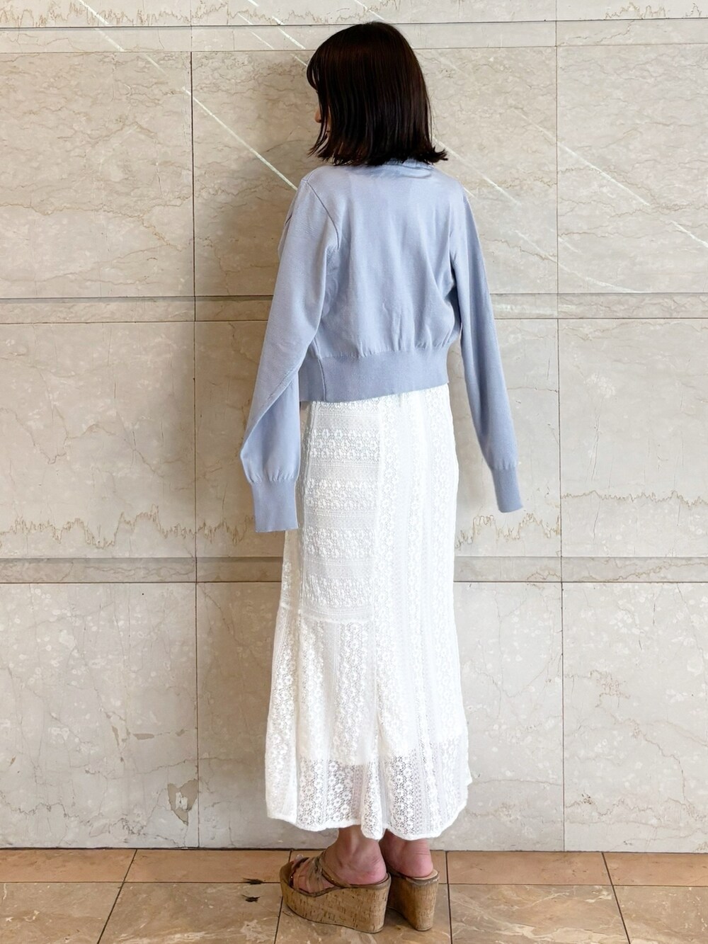 ホワイト系のワンピース、ブラウン系のサンダル、ブルー系のカーディガン/ボレロを着用したレディースの夏コーディネートの3枚目の写真