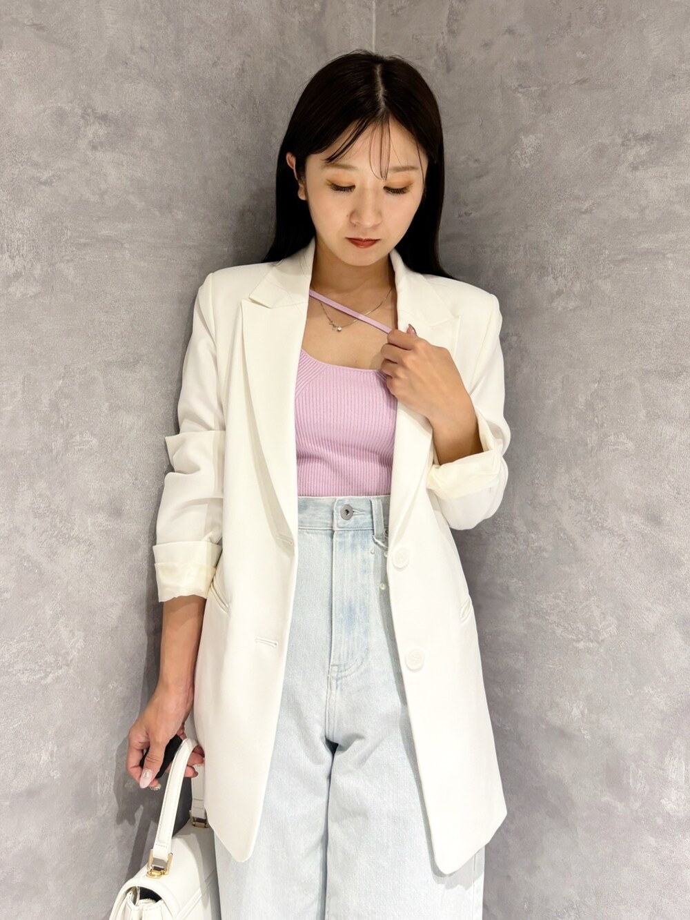 ブルー系のデニムパンツ、ホワイト系のパンプス、ホワイト系のハンドバッグを着用したレディースの冬コーディネートの7枚目の写真