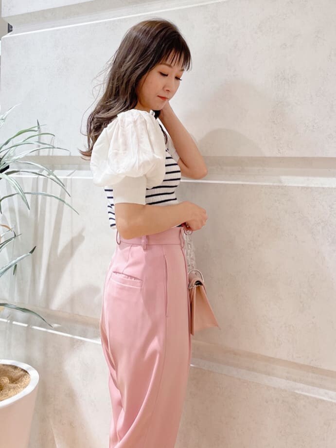 ベージュ系のパンプス、ピンク系のショルダーバッグ、ホワイト系のニット/セーターを着用したレディースの春コーディネートの5枚目の写真