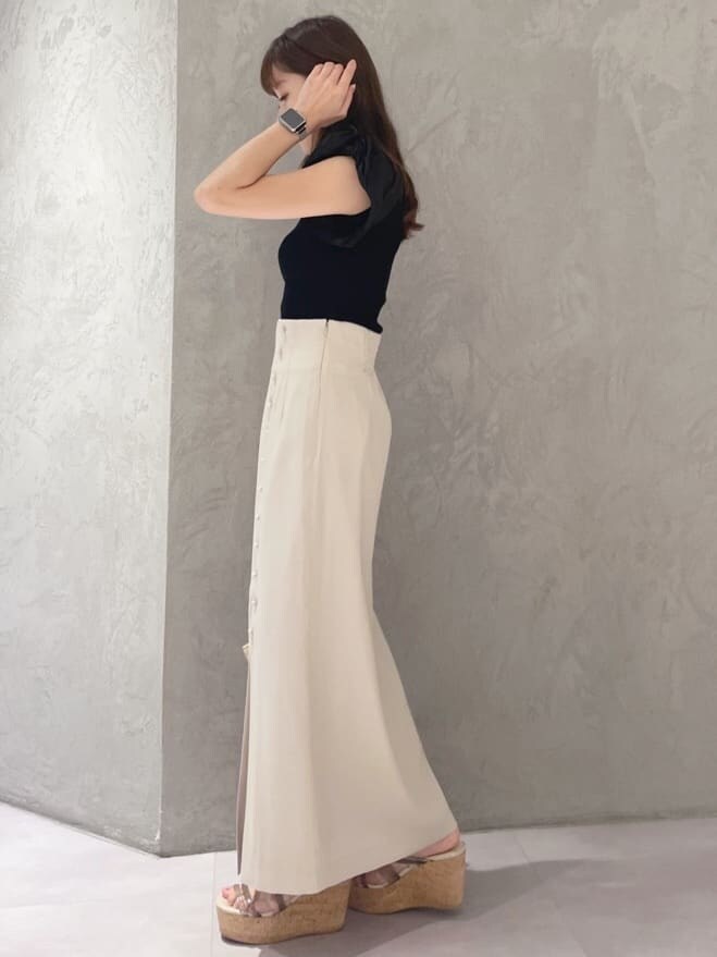 グリーン系のサンダル、ブラック系のニット/セーター、ベージュ系のスカートを着用したレディースの夏コーディネートの3枚目の写真