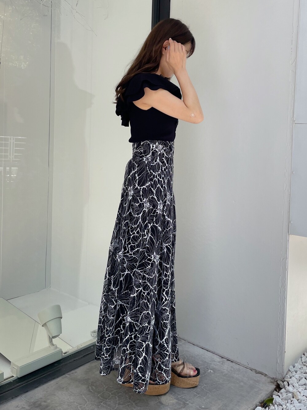 ブラック系のスカート、ブラック系のサンダル、ブラック系のニット/セーターを着用したレディースの夏コーディネートの5枚目の写真