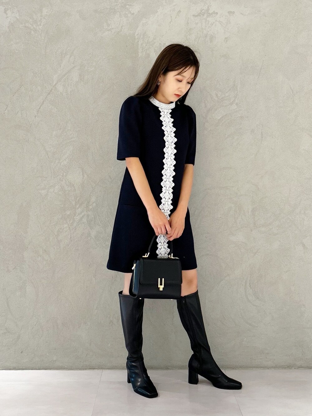 ブルー系のワンピース、ブラック系のブーツ、ブラック系のショルダーバッグを着用したレディースの秋コーディネートの5枚目の写真