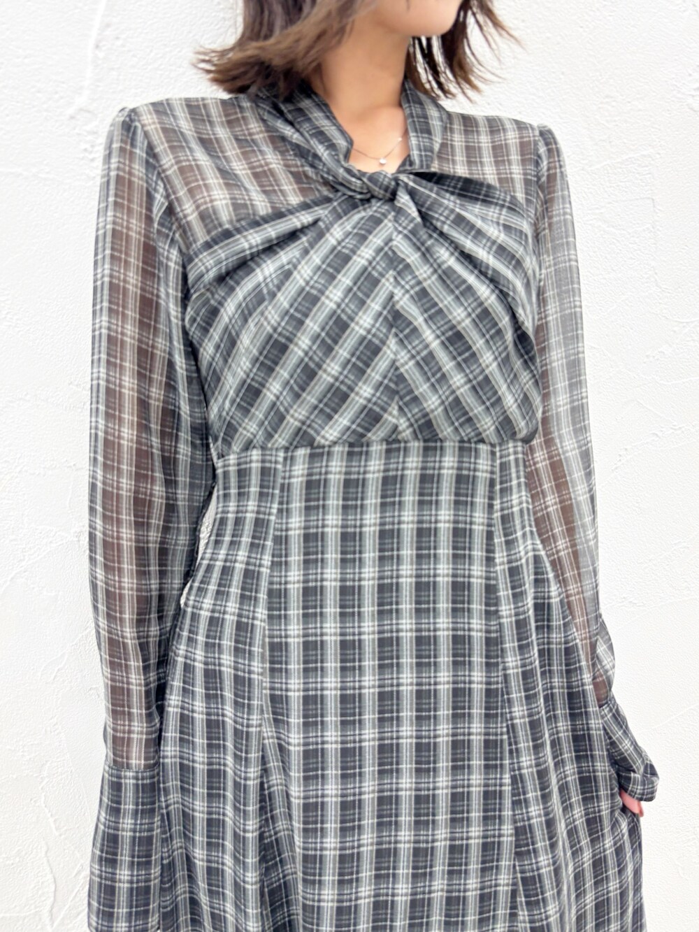 ブラック系のワンピース、ブラック系のブーツを着用したレディースの秋コーディネートの4枚目の写真