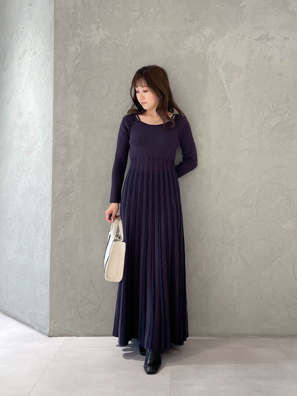 ホワイト系のハンドバッグ、グレー系のワンピースを着用したレディースの春コーディネートの2枚目の写真