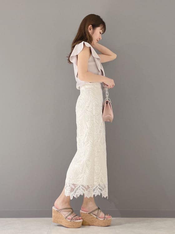 ホワイト系のスカート、ピンク系のショルダーバッグ、グリーン系のサンダルを着用したレディースの春コーディネートの6枚目の写真