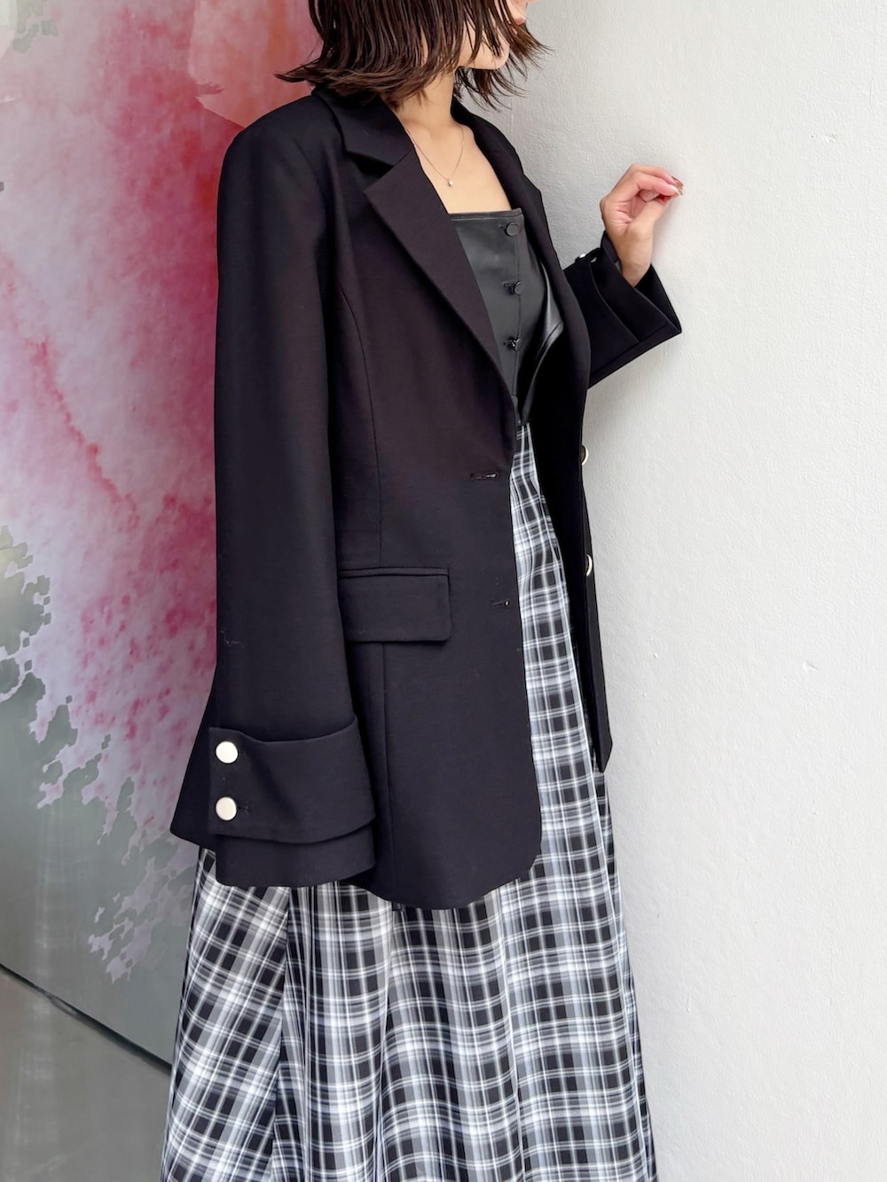 ブラック系のワンピース、ブラック系のブーツ、ブラック系のテーラードジャケットを着用したレディースの秋コーディネートの3枚目の写真