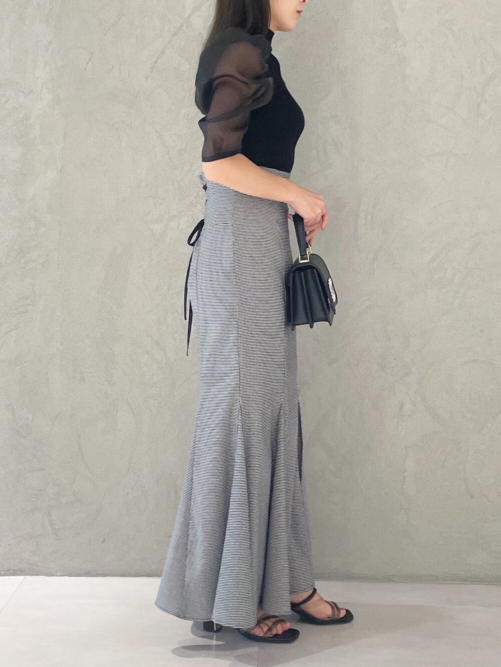 その他のスカート、ブラック系のニット/セーター、ブラック系のサンダルを着用したレディースの夏コーディネートの2枚目の写真