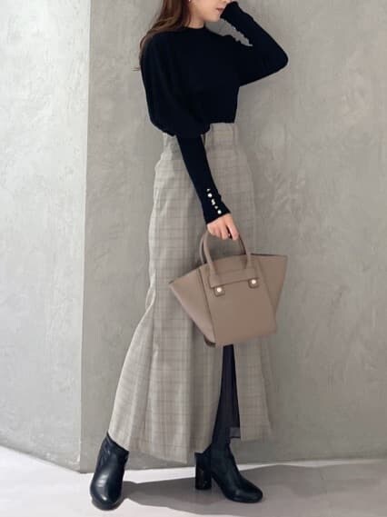 ブラウン系のハンドバッグ、グレー系のスカート、ブラック系のニット/セーターを着用したレディースの秋コーディネートの9枚目の写真