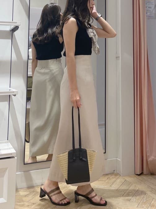 ブラック系のサンダル、ベージュ系のスカート、ブラック系のニット/セーターを着用したレディースの夏コーディネートの2枚目の写真