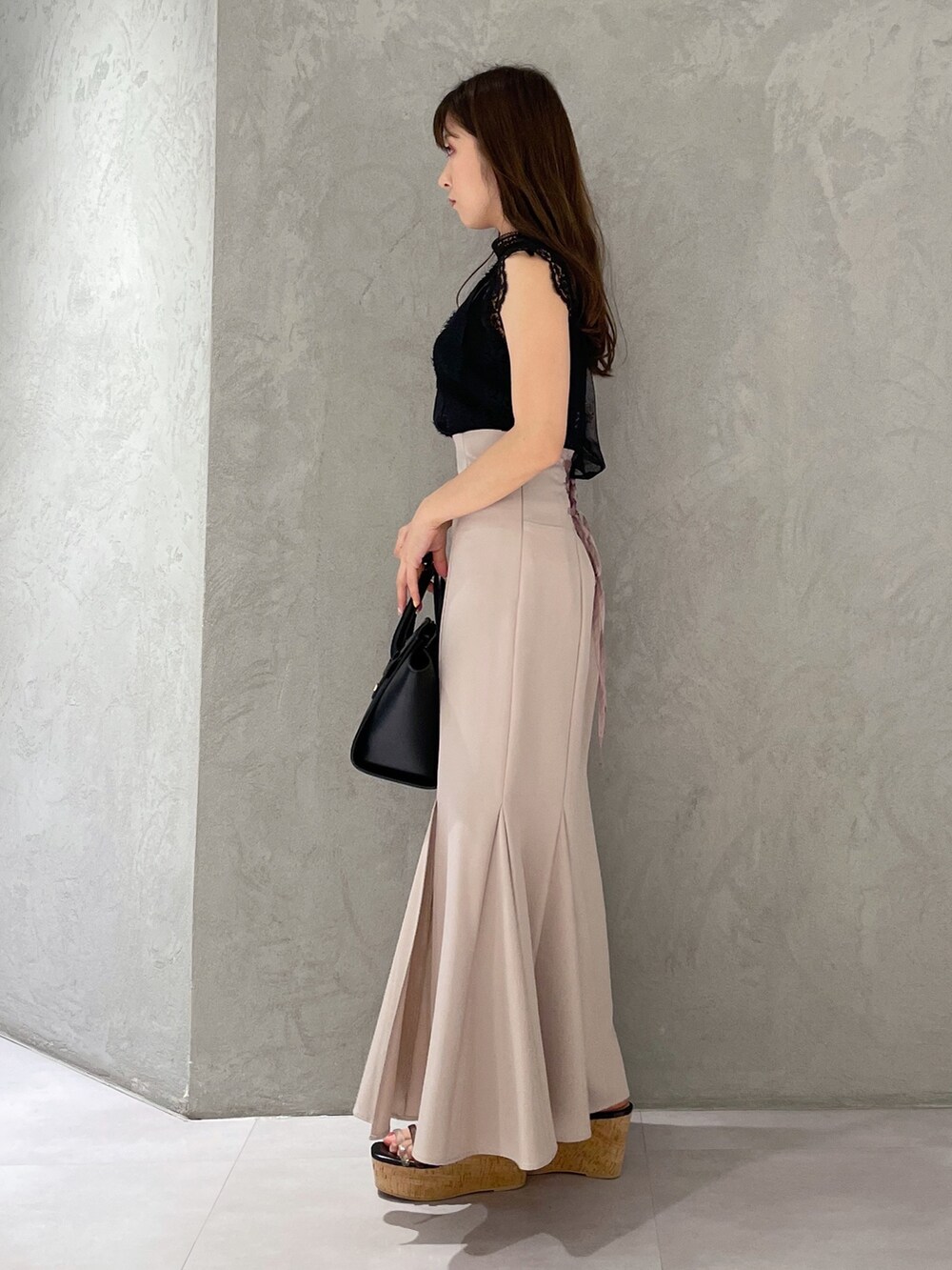 ベージュ系のスカート、ブラック系のサンダル、ブラック系のトートバッグを着用したレディースの夏コーディネートの2枚目の写真