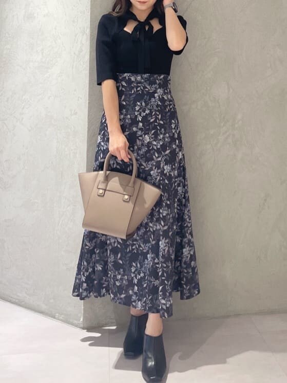 ブラック系のニット/セーター、ブラウン系のハンドバッグ、ブルー系のスカートを着用したレディースの夏コーディネートの7枚目の写真