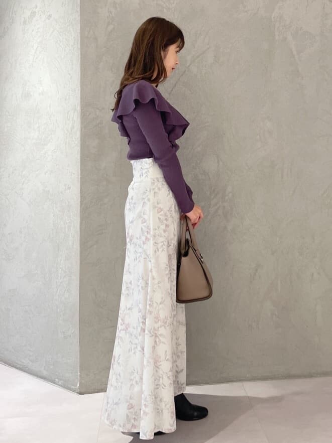 ピンク系のスカート、ブラウン系のハンドバッグ、パープル系のニット/セーターを着用したレディースの秋コーディネートの3枚目の写真