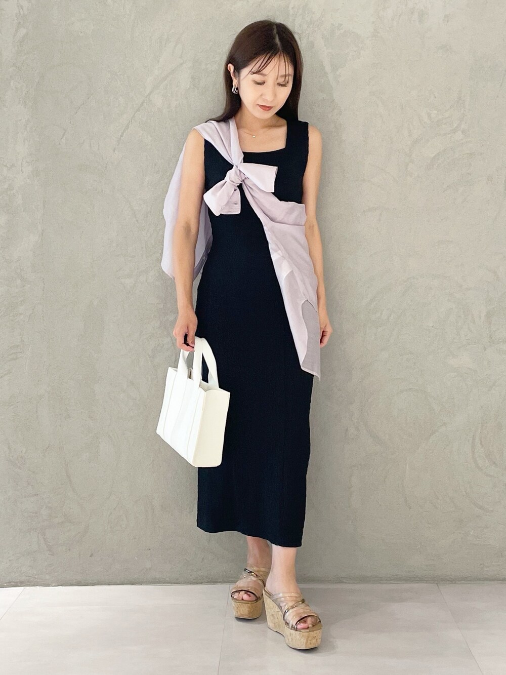 ピンク系のトートバッグ、ブラウン系のサンダル、ブラック系のワンピースを着用したレディースの夏コーディネートの5枚目の写真