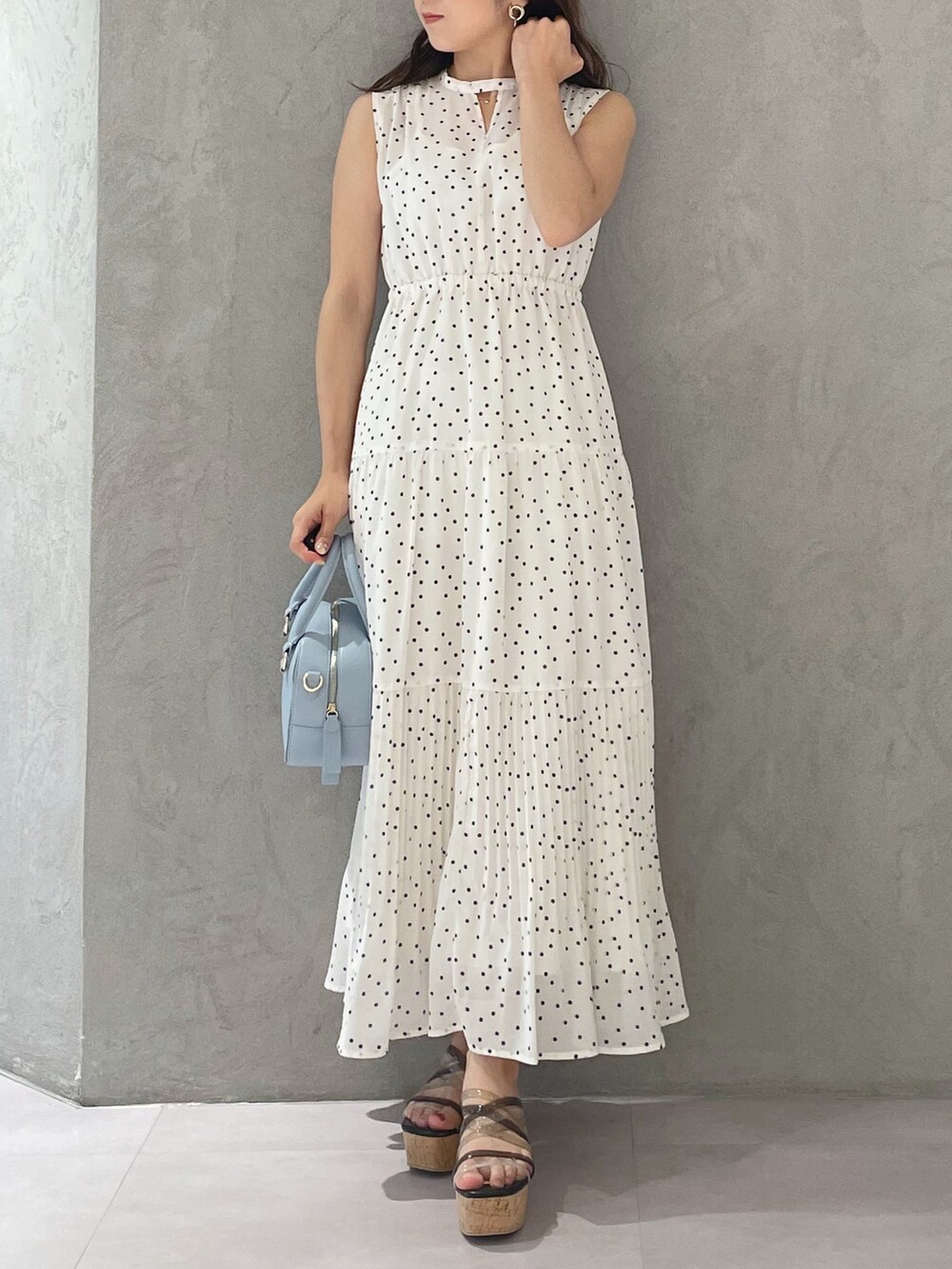 ホワイト系のワンピース、ブラック系のサンダル、ブルー系のボストンバッグを着用したレディースの夏コーディネートの4枚目の写真