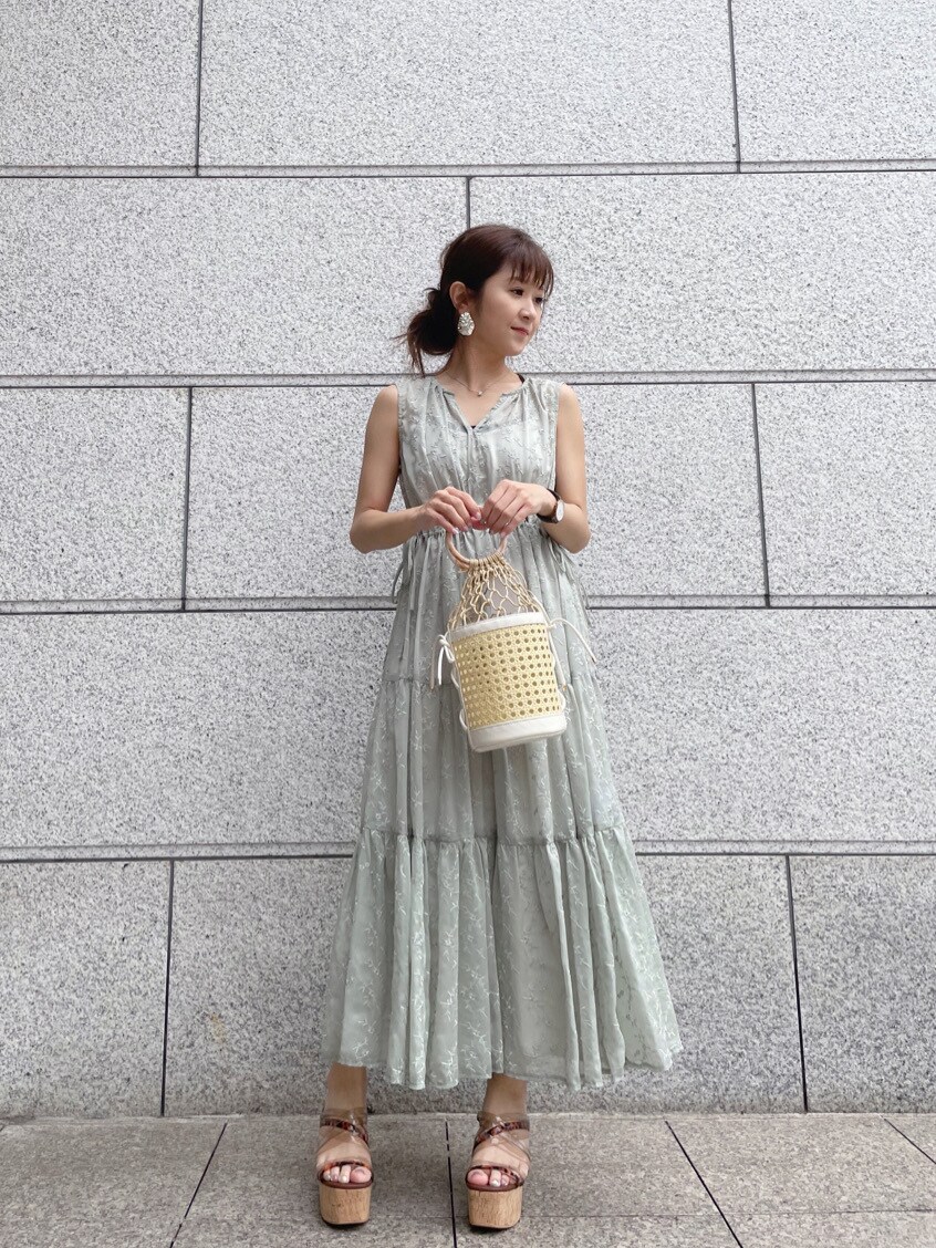 ベージュ系のサンダル、ホワイト系のハンドバッグ、グリーン系のワンピースを着用したレディースの春コーディネートの6枚目の写真