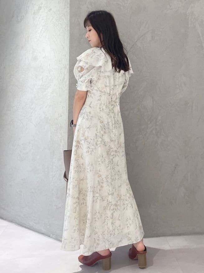 イエロー系のワンピース、ブラック系のサンダル、ブラウン系のハンドバッグを着用したレディースの夏コーディネートの6枚目の写真