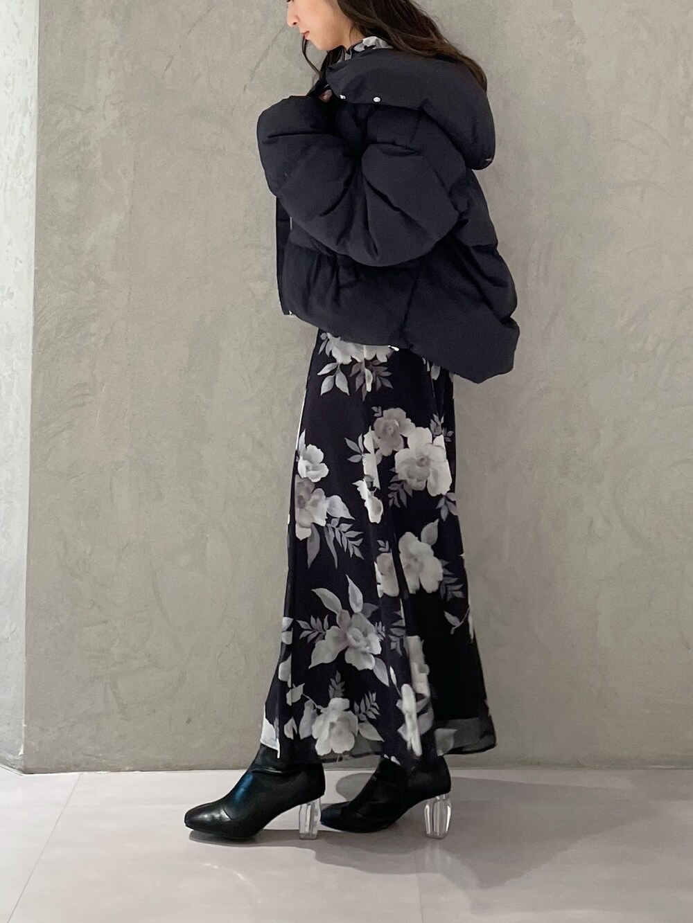 ブラック系のワンピース、ブラック系のダウンジャケット/コート、ブラック系のブーツを着用したレディースの冬コーディネートの3枚目の写真