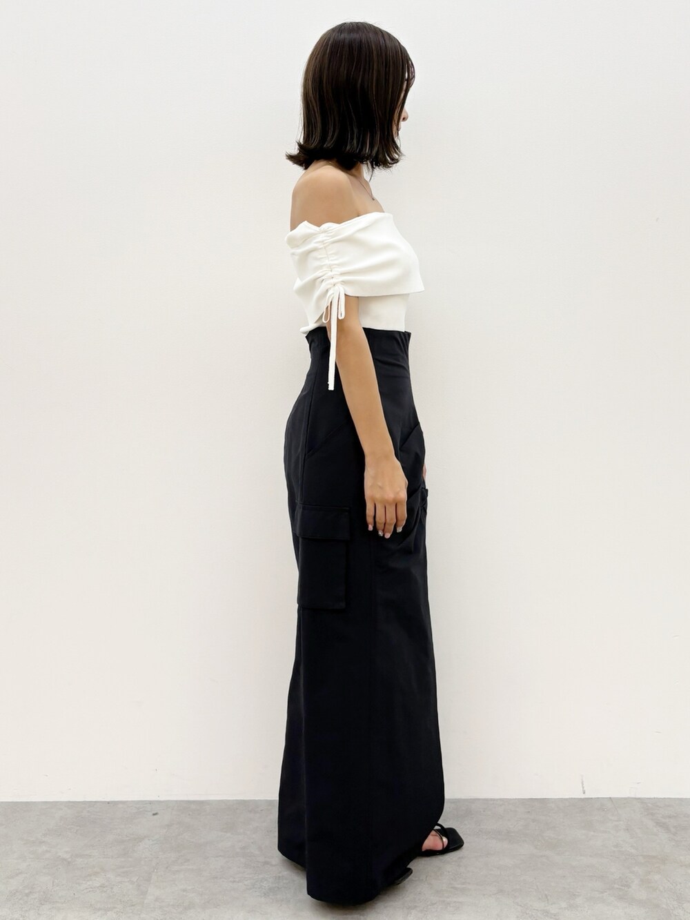 ブラック系のスカート、ホワイト系のニット/セーターを着用したレディースの夏コーディネートの6枚目の写真