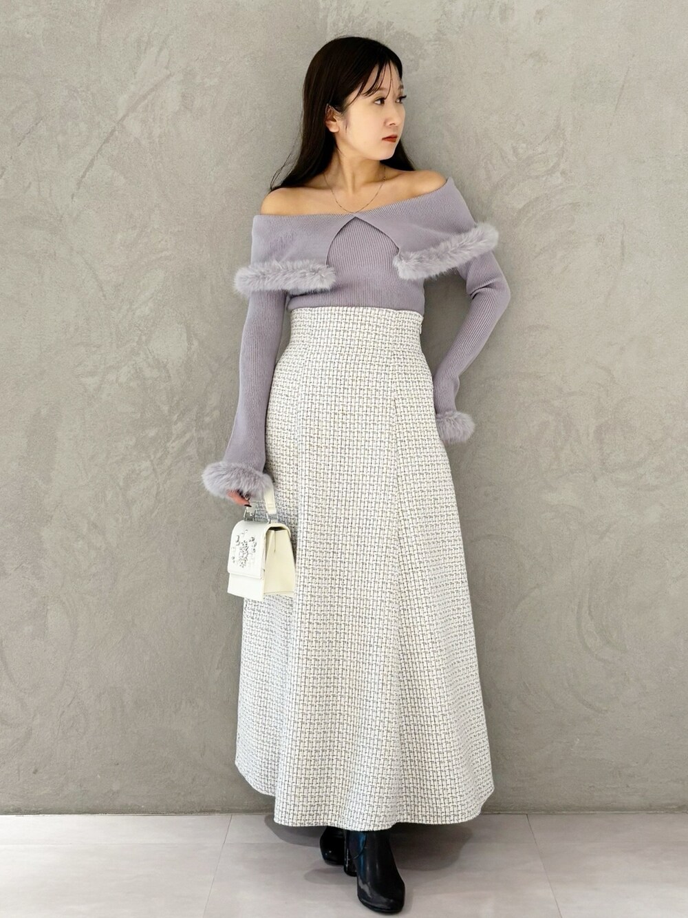 ホワイト系のスカート、ブラック系のブーツ、ホワイト系のショルダーバッグを着用したレディースの冬コーディネートの7枚目の写真