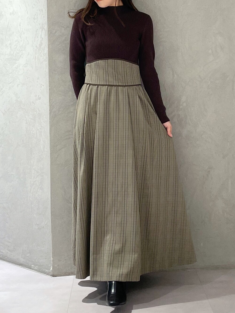 ブラウン系のワンピース、ブラック系のブーツを着用したレディースの冬コーディネートの3枚目の写真