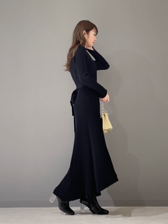 ブラック系のワンピース、ブラック系のその他シューズ、イエロー系のショルダーバッグを着用したレディースの冬コーディネートの3枚目の写真