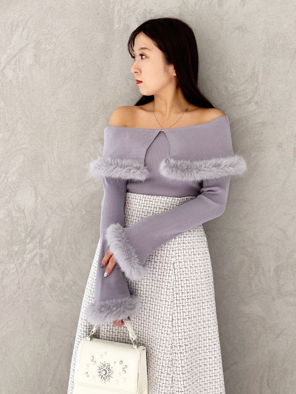 ホワイト系のスカート、ブラック系のブーツ、ホワイト系のショルダーバッグを着用したレディースの冬コーディネートの4枚目の写真