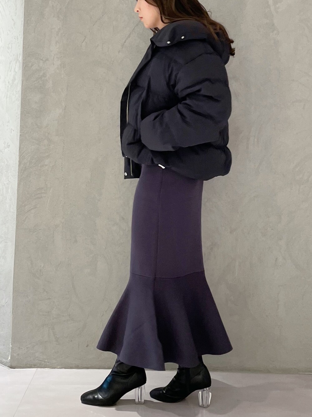 ブラック系のダウンジャケット/コート、ブルー系のワンピース、ブラック系のブーツを着用したレディースの冬コーディネートの4枚目の写真