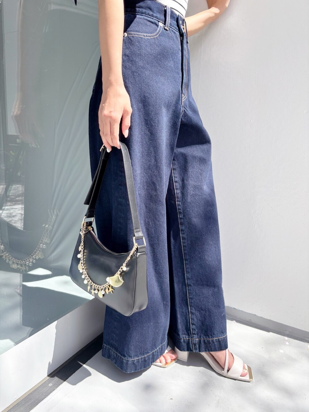 ブルー系のデニムパンツ、その他のニット/セーター、ホワイト系のサンダルを着用したレディースの夏コーディネートの7枚目の写真