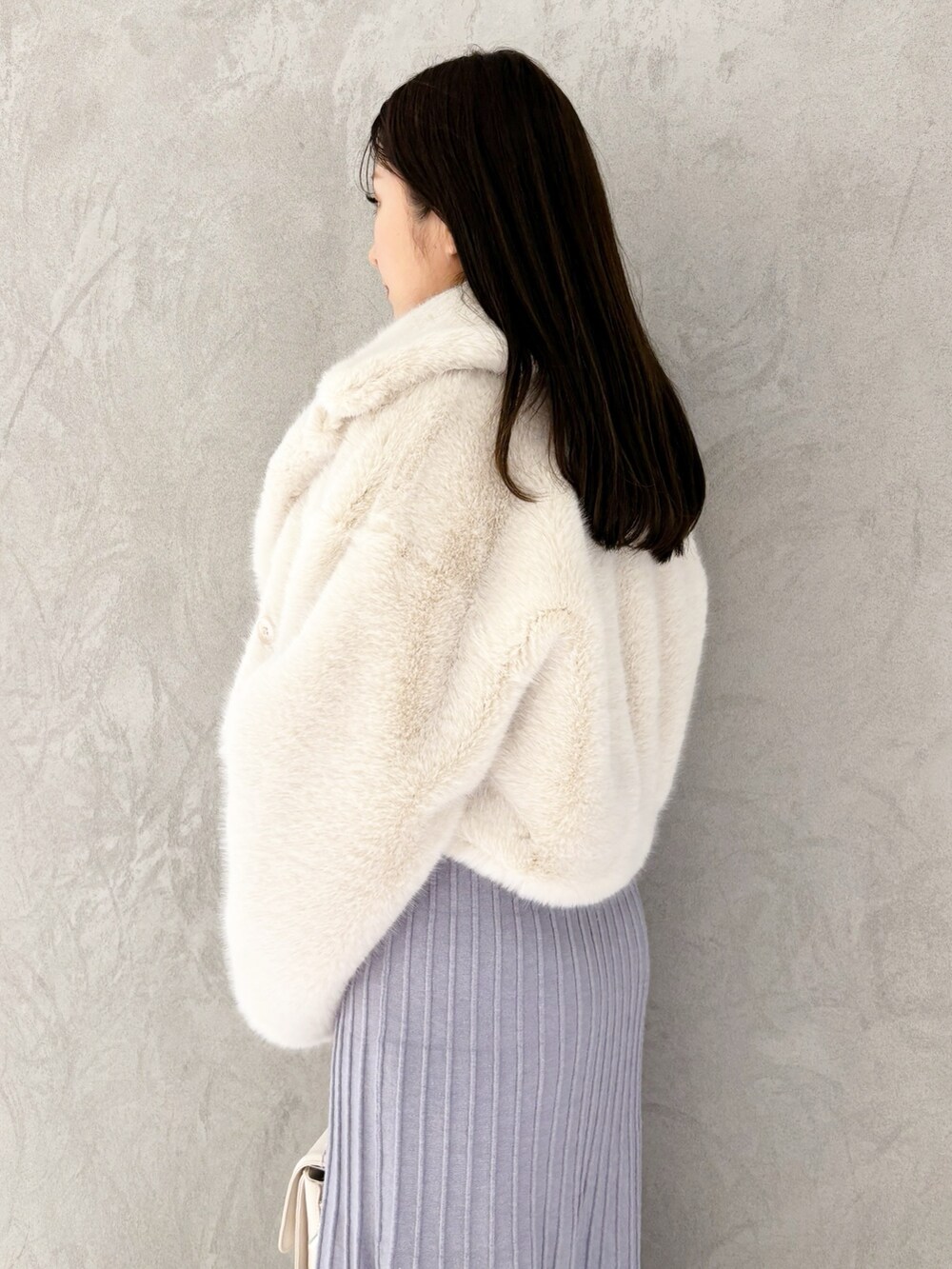 ブルー系のワンピース、ブラック系のブーツ、ホワイト系のその他アウターを着用したレディースの冬コーディネートの3枚目の写真