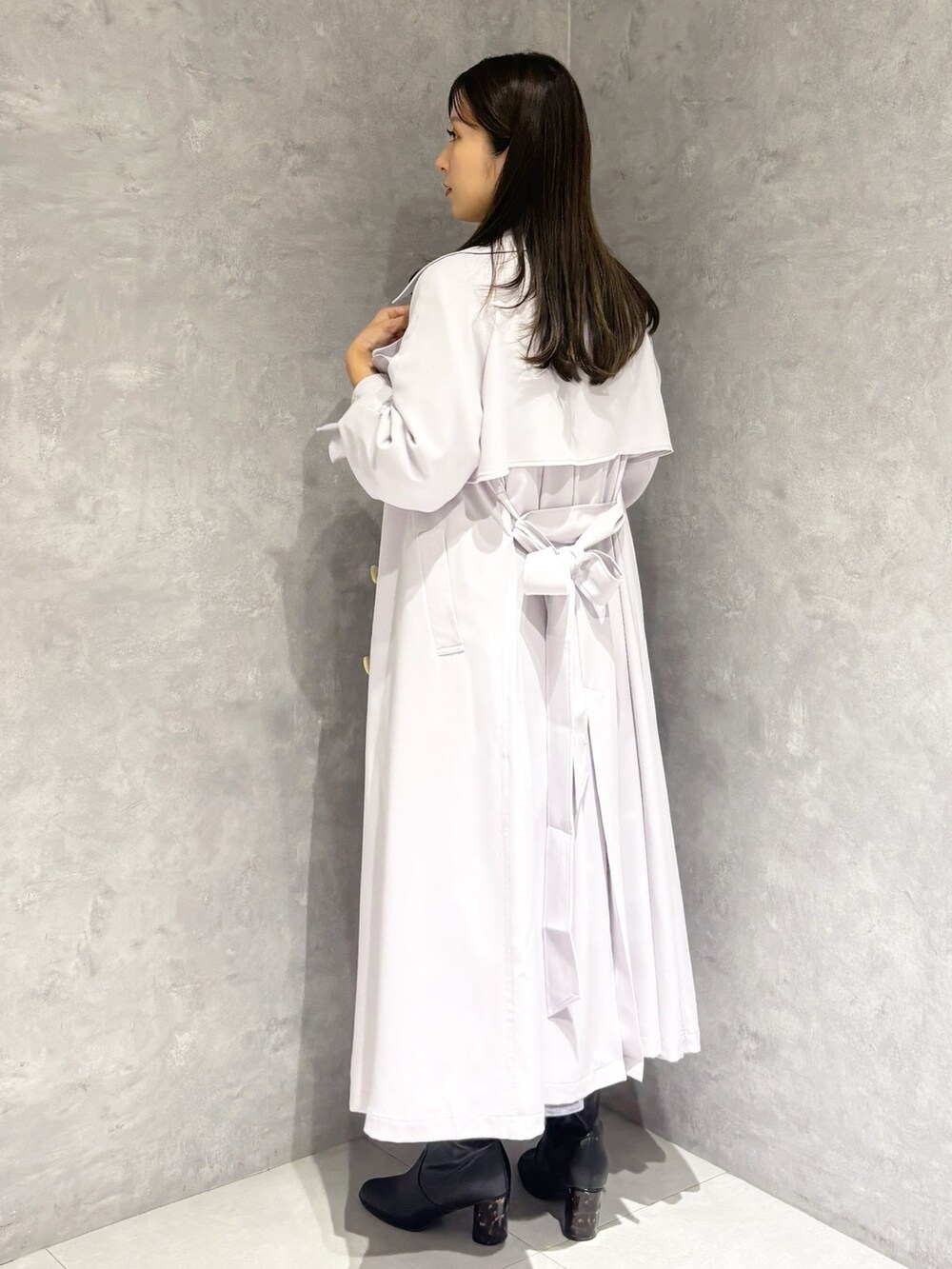 パープル系のスカート、ブラック系のブーツ、ホワイト系のハンドバッグを着用したレディースの冬コーディネートの5枚目の写真