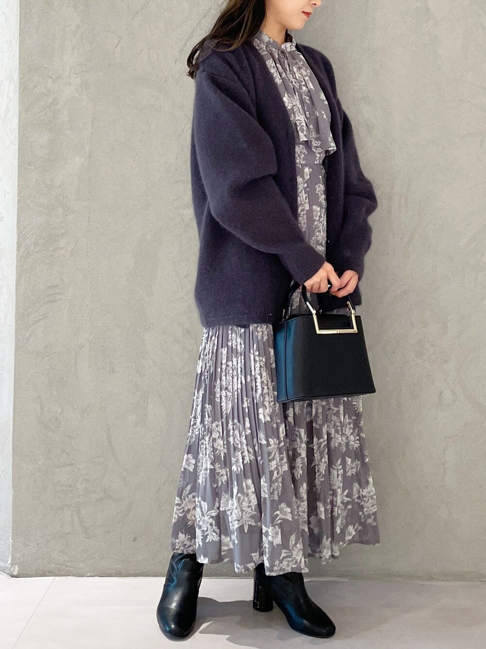 パープル系のワンピース、ブラック系のブーツ、ブラック系のハンドバッグを着用したレディースの秋コーディネートの2枚目の写真