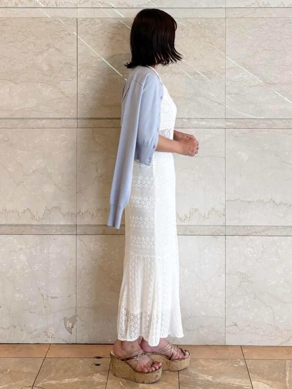 ホワイト系のワンピース、ブラウン系のサンダル、ブルー系のカーディガン/ボレロを着用したレディースの夏コーディネートの2枚目の写真