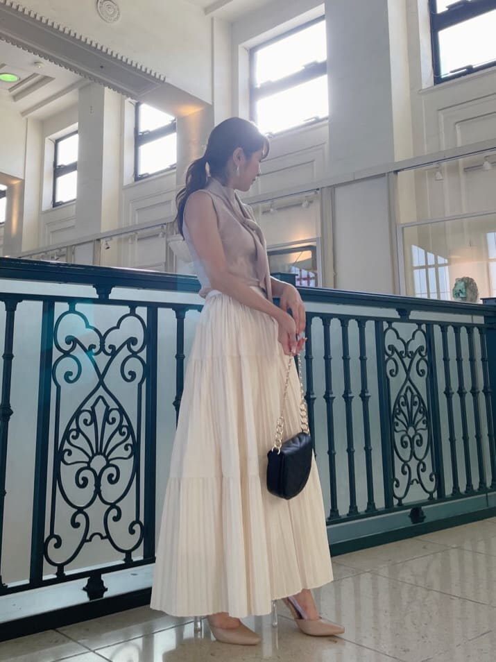 ホワイト系のスカート、ベージュ系のパンプス、ピンク系のニット/セーターを着用したレディースの秋コーディネートの2枚目の写真